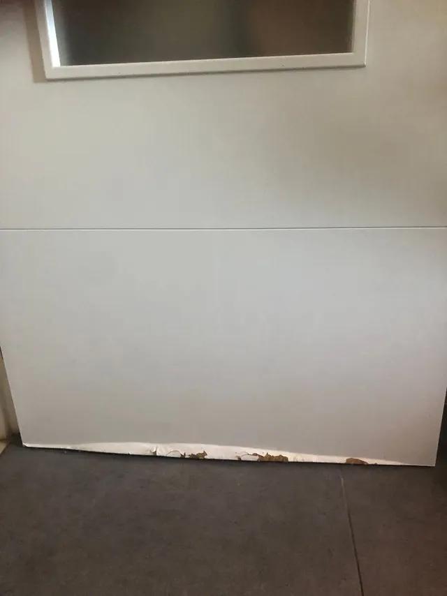 Moisture damage and deterioration at the bottom edge of a door leaf